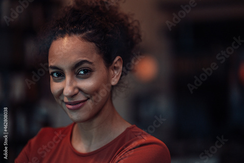 Smiling woman staring whiles sitting at cafe photo