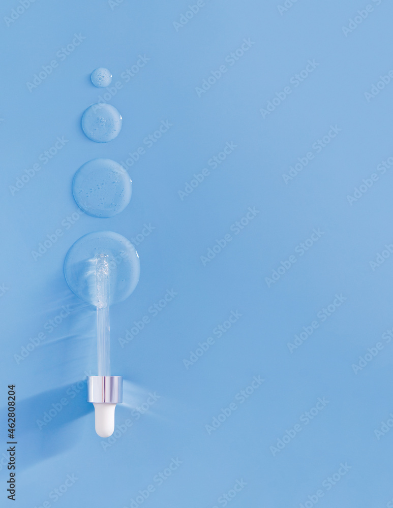 pipette drops of serum on blue background
pipette drops of serum on blue background