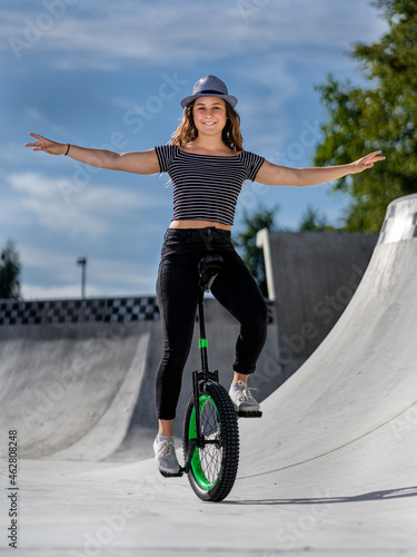 Young woman riding unicycle in skatepark