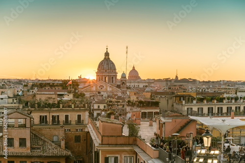 The skyline of Rome with San Carlo al Corso and St. Peter's Basilica before sunset seen from the Spanish Steps, Italy