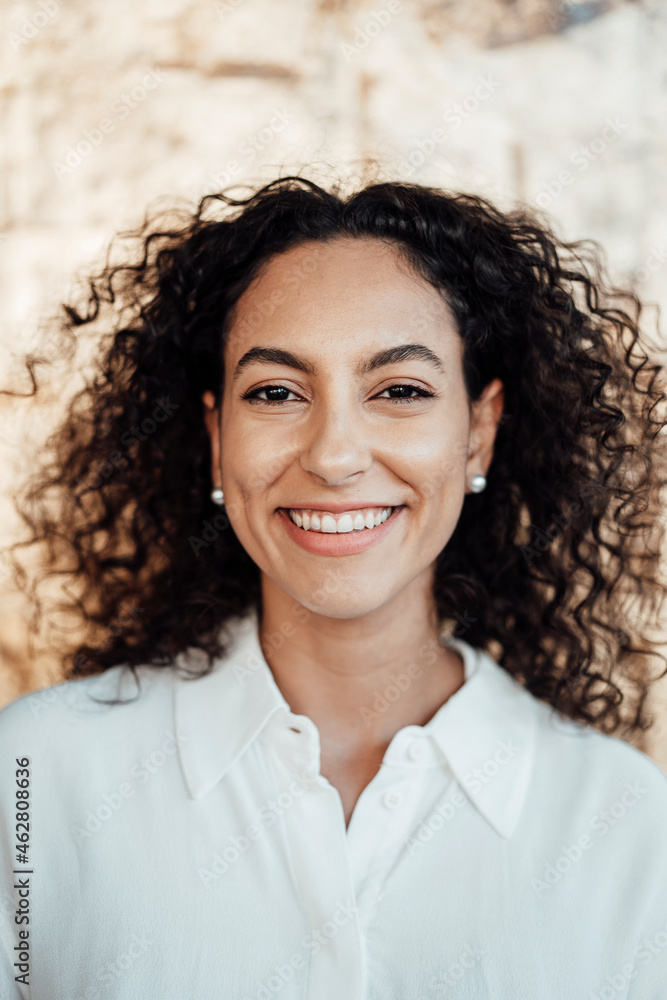 Businesswoman smiling while standing against wall Businesswoman smiling while standing against wall