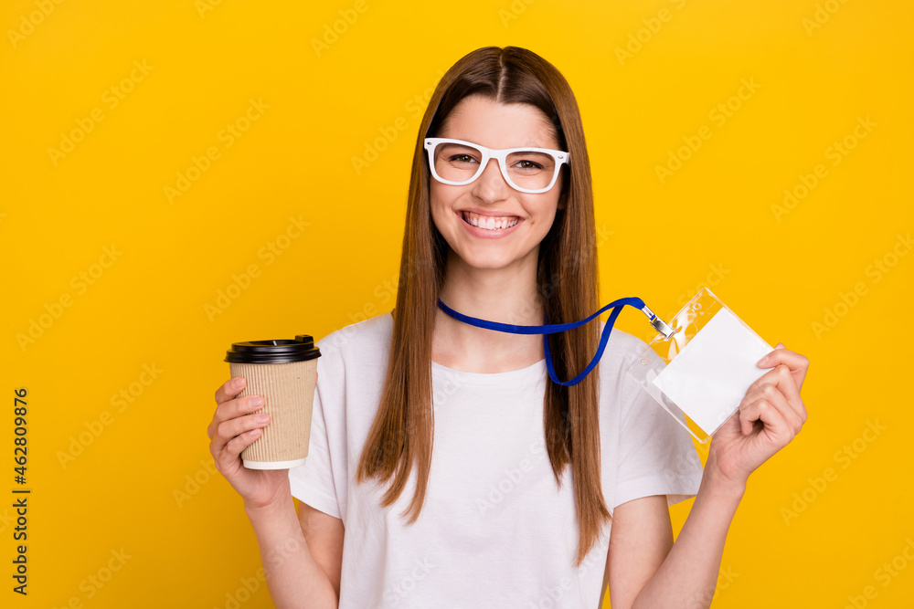 Photo of cheerful young happy positive woman good mood hold coffee name tag isolated on yellow color background - obrazy, fototapety, plakaty 