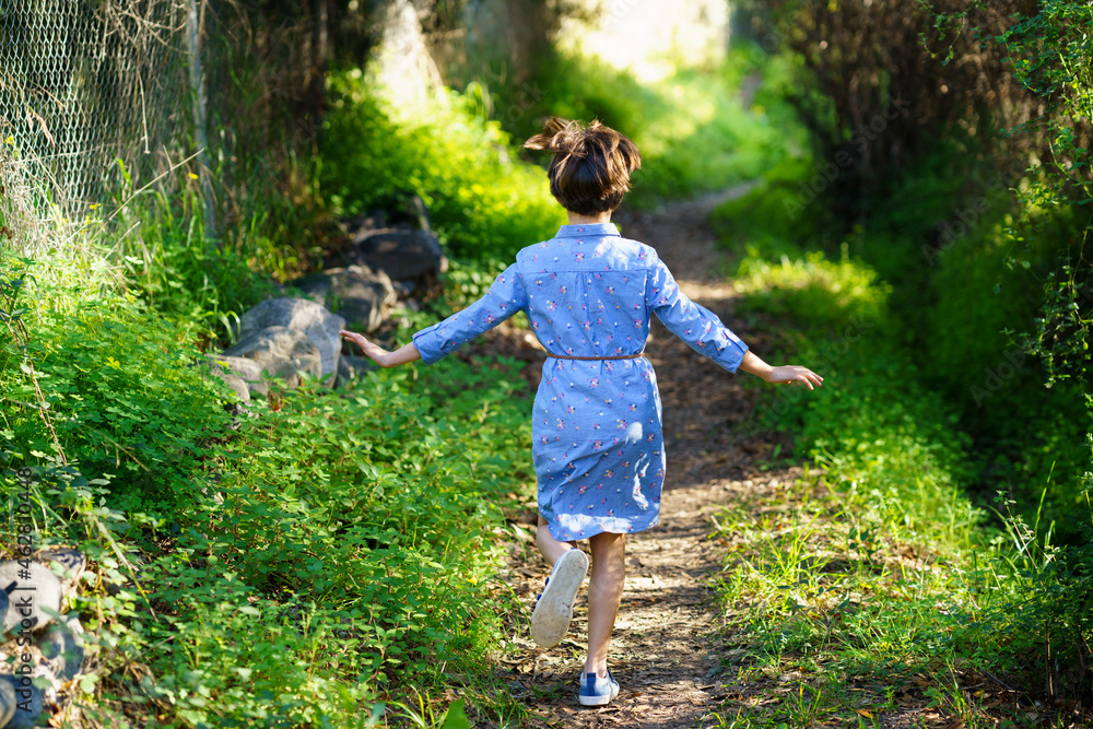 Girl running on a rural path, rear view Girl running on a rural path, rear view