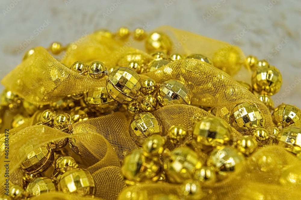 Pile of yellow New Year's and Christmas decorations with beads and ribbon