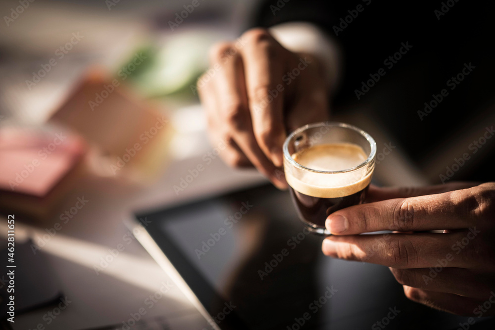 Businessman holding cup of coffee in his office Businessman holding cup of coffee in his office