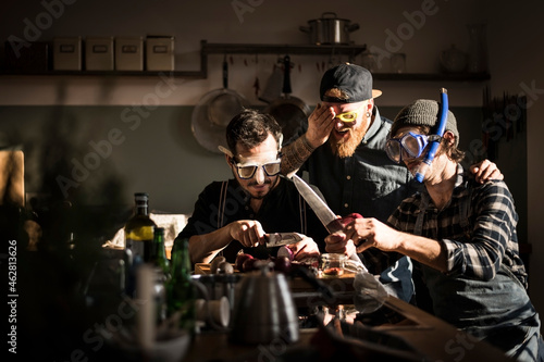 Friends chopping onions with swimming goggles photo