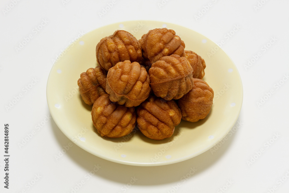 Small walnut-flavored cakes in the size and shape of a walnut on the plate. Isolate on white background.
Small walnut-flavored cakes in the size and shape of a walnut on the plate. Isolate on white background.