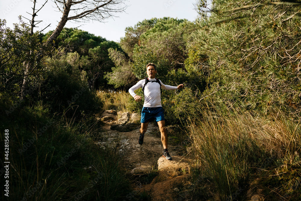 Man running in forest during sunny day Man running in forest during sunny day