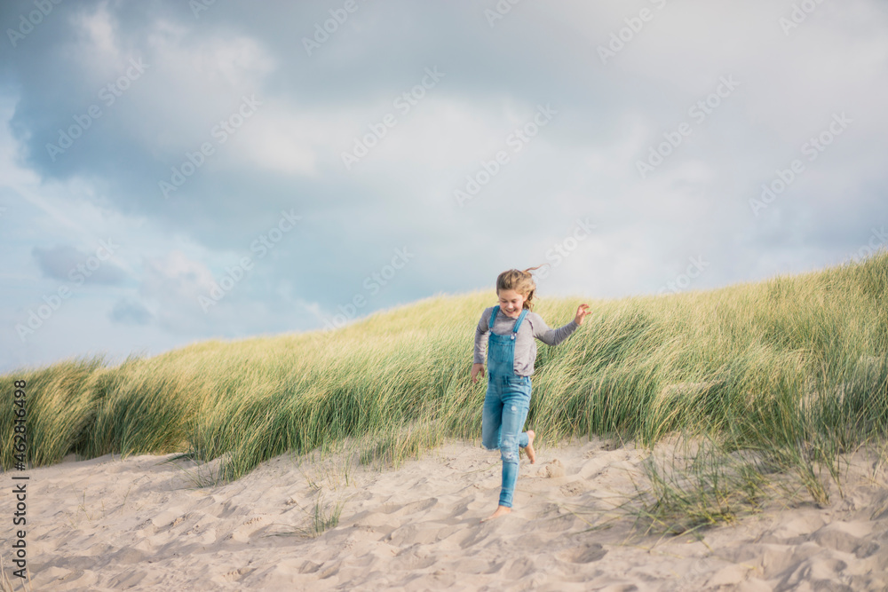Happy girl having fun on the beach, running in the dunes Happy girl having fun on the beach, running in the dunes