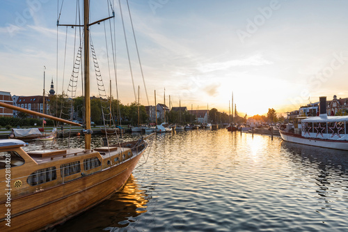 Germany, Mecklenburg-Western Pomerania, Greifswald, Sailing ships moored in harbor at sunset photo