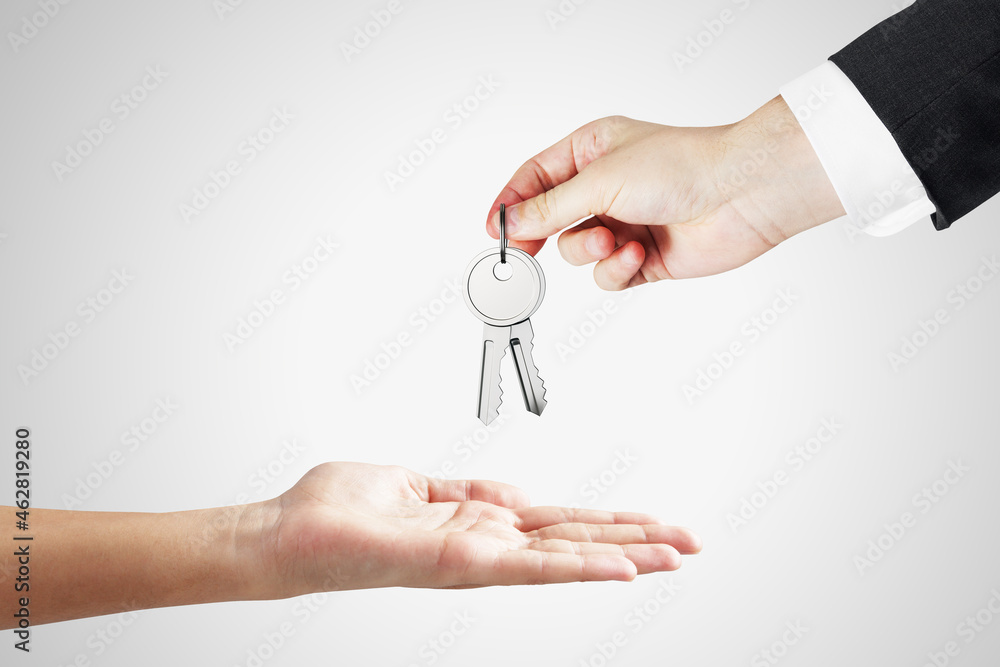 Close up of businessman handing keys on white background. Housing, property, investment and purchase concept. Close up of businessman handing keys on white background. Housing, property, investment and purchase concept.