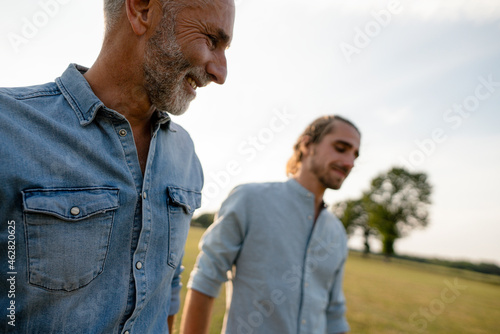 Happy father with adult son on a meadow in the countryside photo