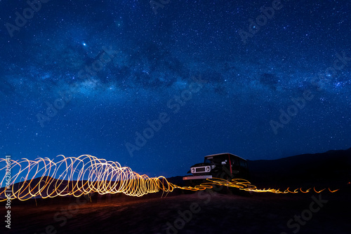 Indonesia, East Java, Spiral light trails in front of car parked in Bromo Tengger Semeru National Park at night photo