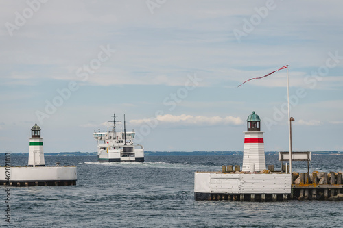 Denmark, Region of Southern Denmark, Soby, Two coastal lighthouses with ship sailing away in background photo