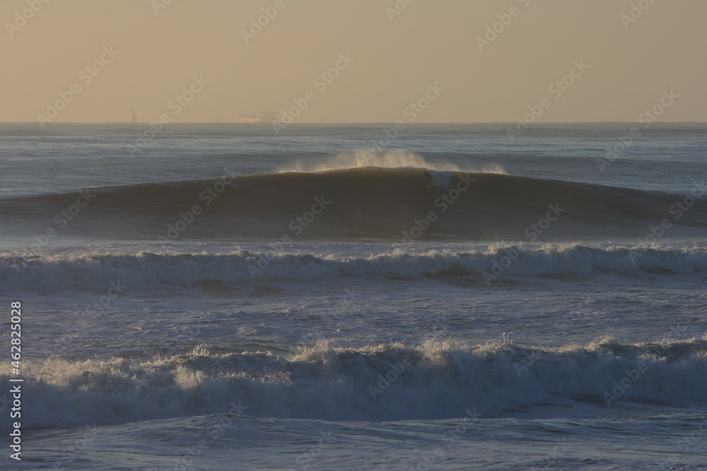 surfer paddling into a large wave at Ocean Beach. San Francisco. California. USA