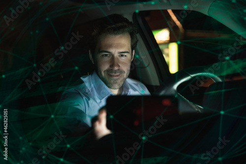 Businessman using navigation device in car at night