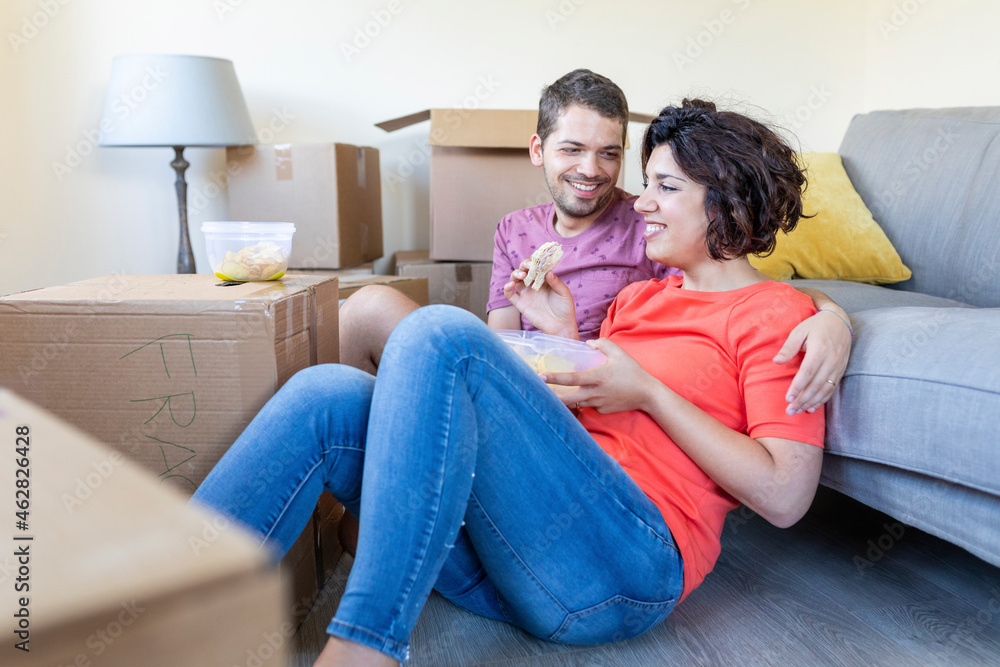 Happy couple moving into new home taking a break and having lunch Happy couple moving into new home taking a break and having lunch
