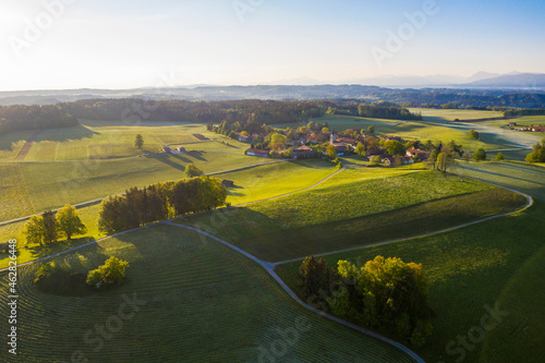 Germany, Bavaria, Peretshofen, Drone view of countryside village at summer sunset photo