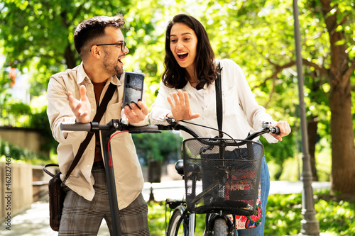 Happy funny couple with bicycle in the park. Loving couple enjoying together outdoors..