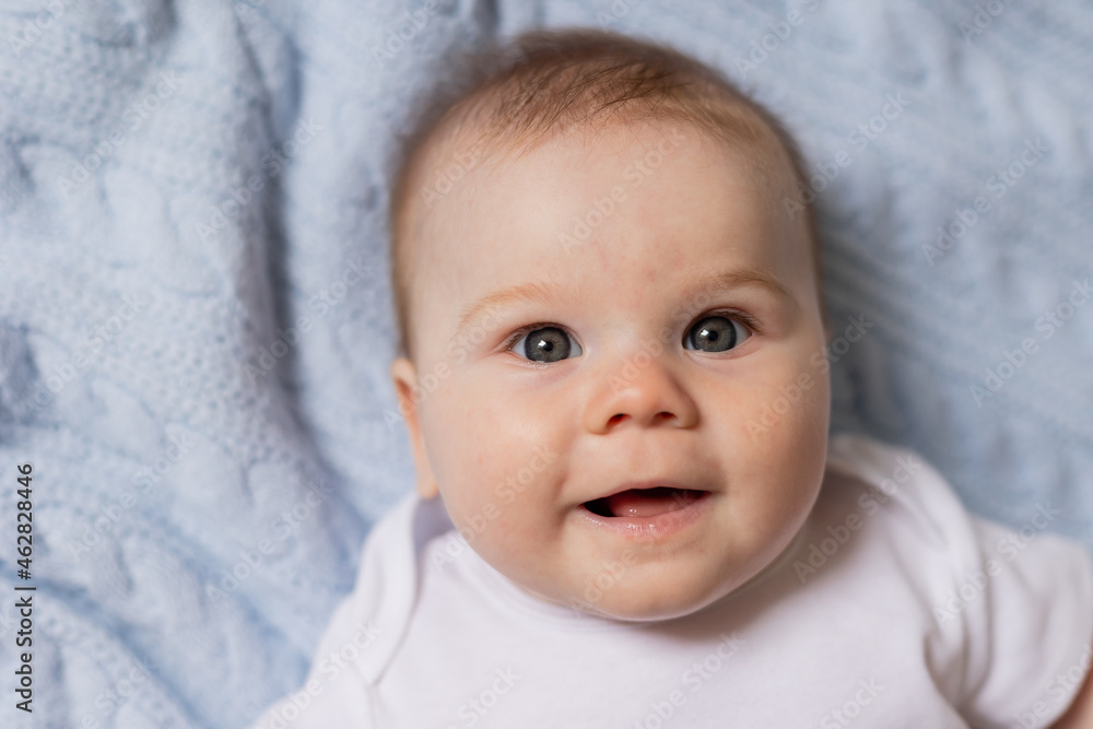 portrait of cute smiling newborn baby lying on his back on blue knitted blanket. breastfeeding. concept of a happy childhood and motherhood. healthy child. High quality photo portrait of cute smiling newborn baby lying on his back on blue knitted blanket. breastfeeding. concept of a happy childhood and motherhood. healthy child. High quality photo