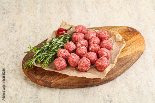 Raw uncooked beef meatballs served rosemary