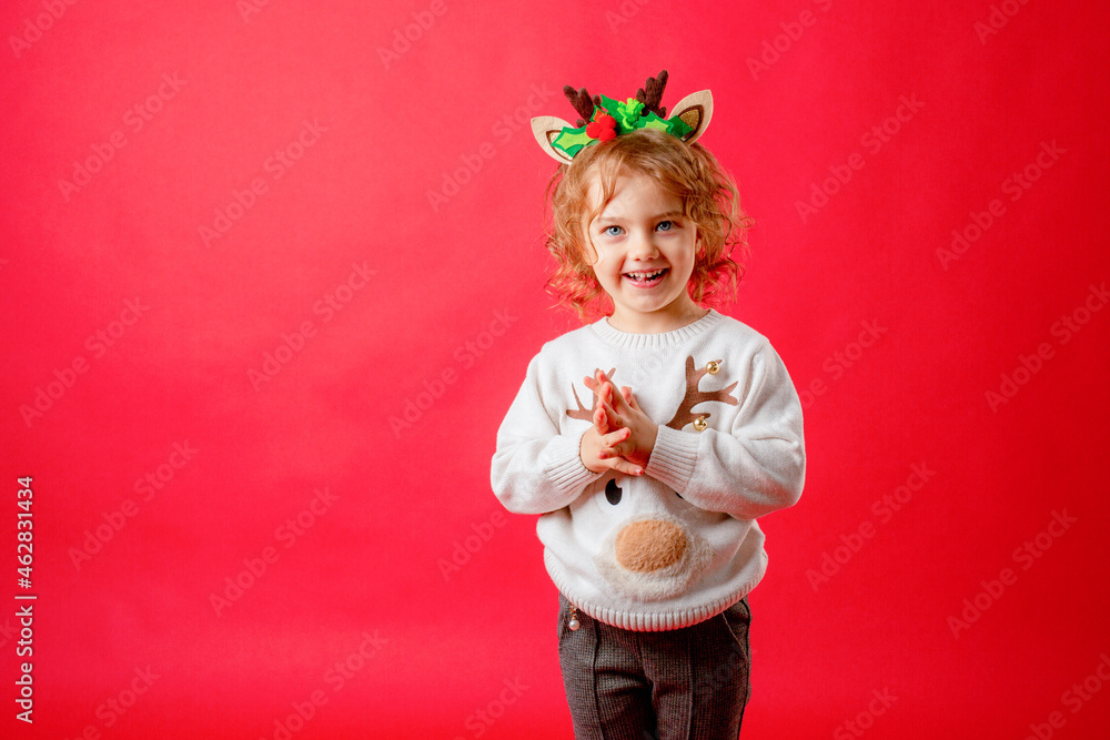 little girl in deer horns on a red background, christmas, new year little girl in deer horns on a red background, christmas, new year