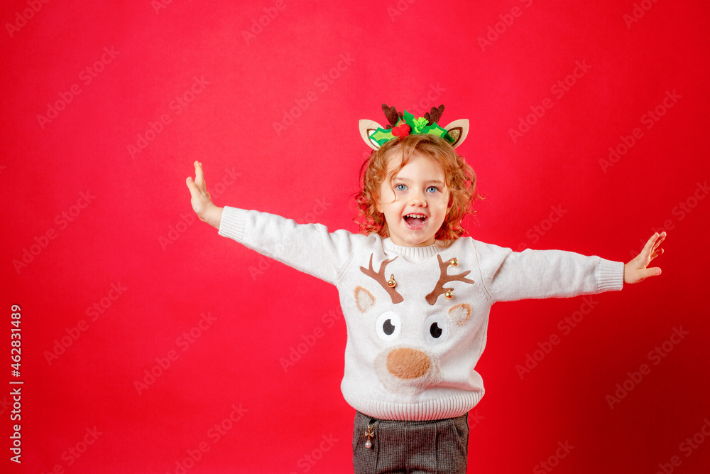 little girl in deer horns on a red background, christmas, new year