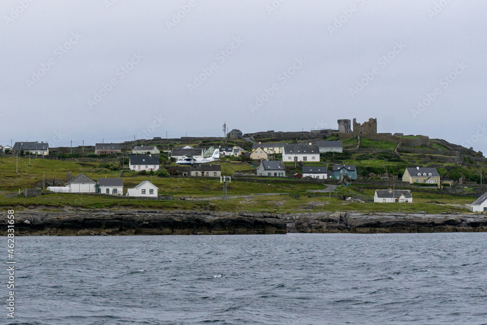 little village with white houses on Aran Islands in ireland with castle ruin on a hill little village with white houses on Aran Islands in ireland with castle ruin on a hill