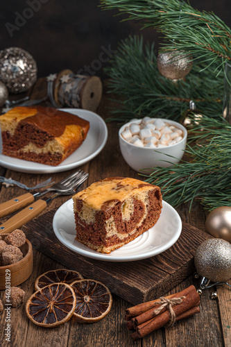 A piece of cake on a festive background with pine branches.