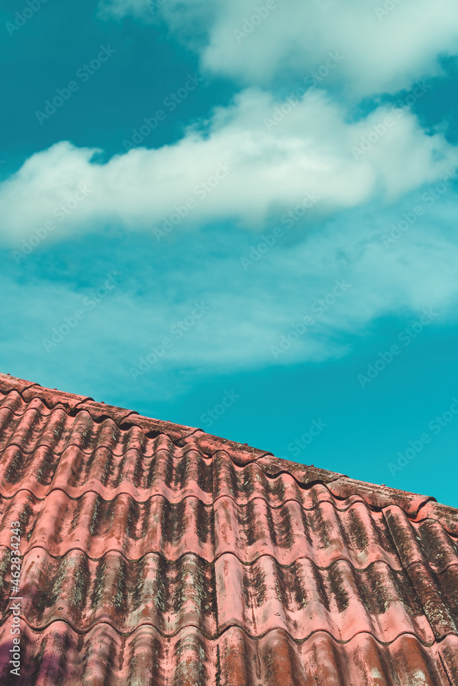 Old house roof with white cloud in background