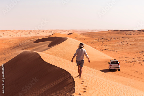 Man walking on a sand dune, Wahiba Sands, Oman photo