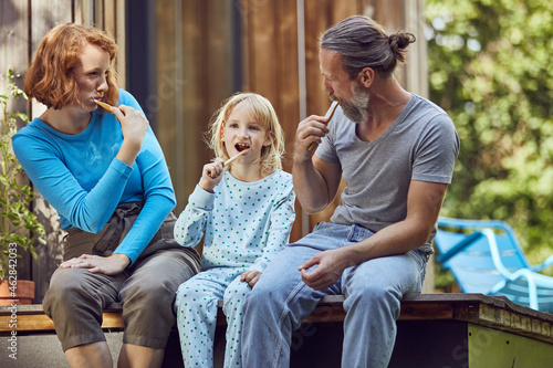 Family brushing teeth while sitting outside tiny house photo