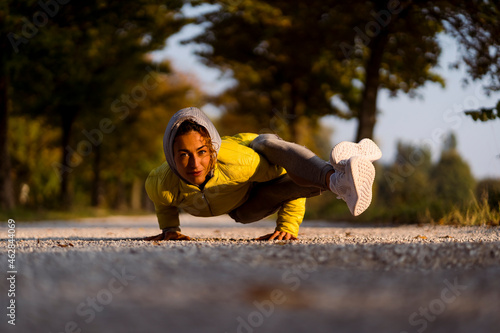 Smiling sportswoman doing handstand while exercising on road photo