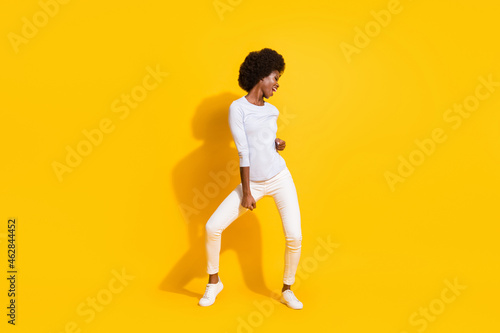 Full size photo of optimistic cool short hair lady dance wear white pullover trousers sneakers isolated on yellow background