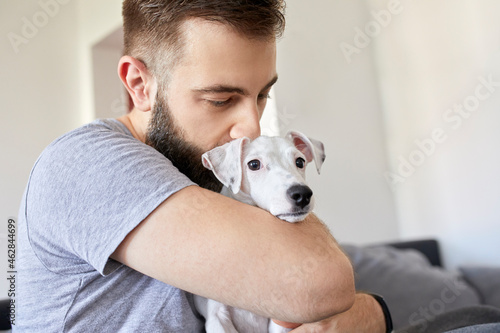 Man cuddling his dog at home