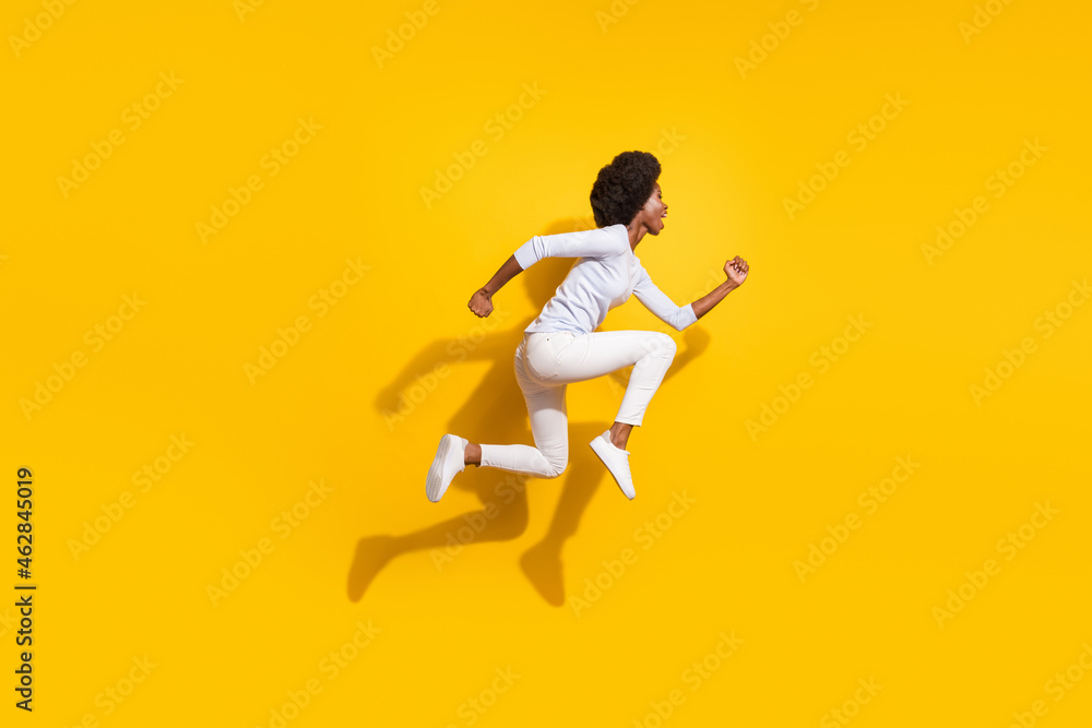 Full body profile side photo of afro american brunette girl run jump empty space isolated on yellow color background