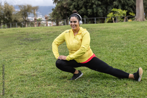 Plus size girl doing stretching day routine outdoor at city park - Focus on face