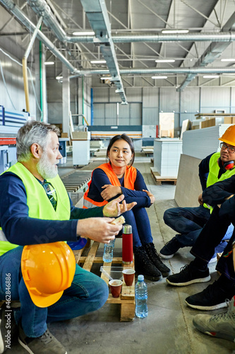 Workers in factory having lunch break together photo