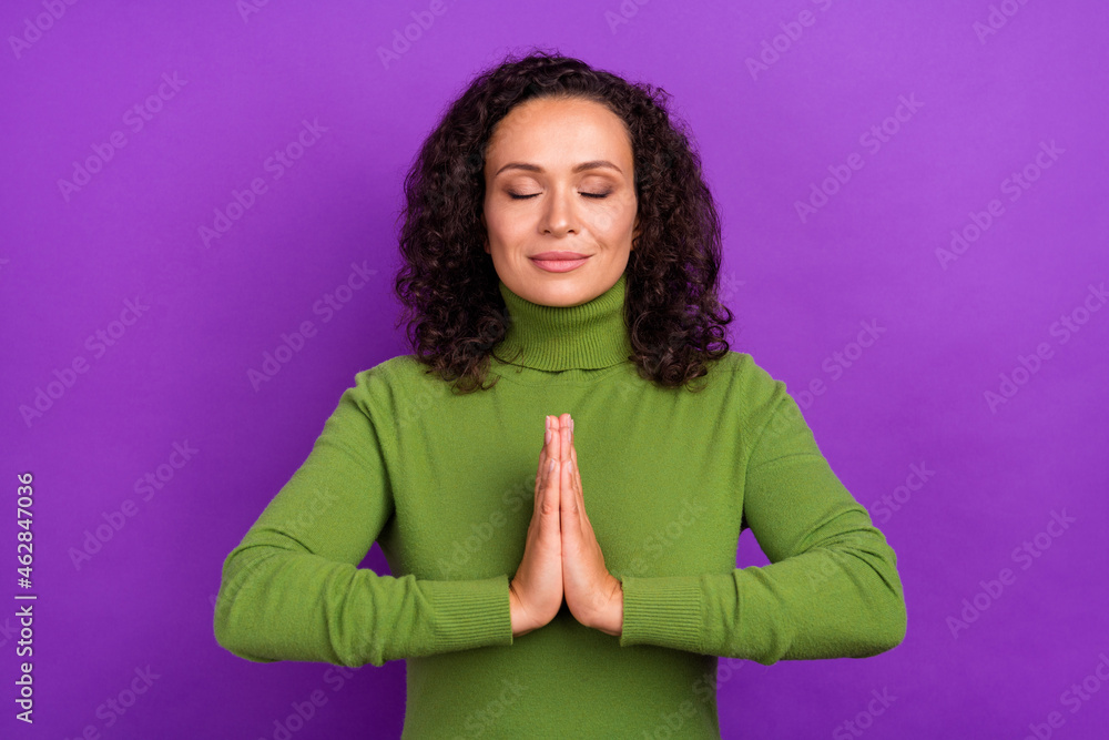 Obraz premium Photo of beautiful dreamy african lady dressed green turtleneck smiling arms together practicing yoga isolated violet color background