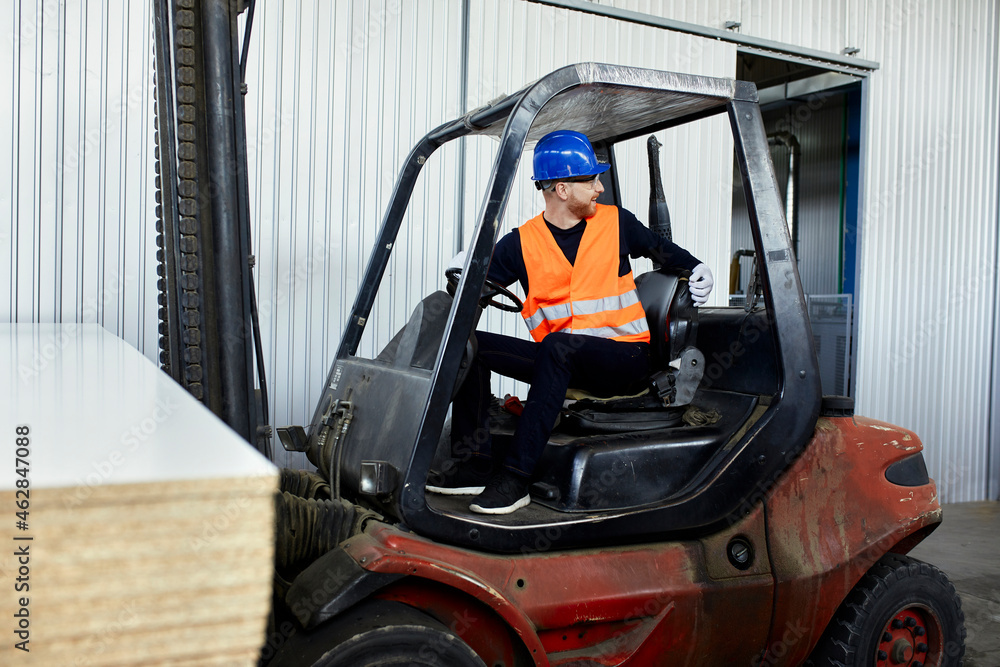 Worker on forklift in factory turning round Worker on forklift in factory turning round