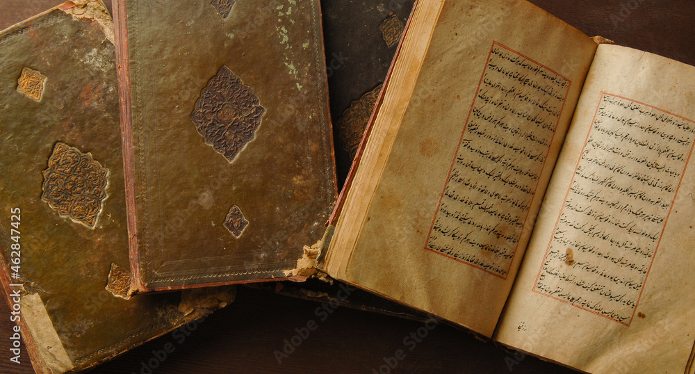 Stack of open ancient books in Arabic. Old Arabic manuscripts and texts