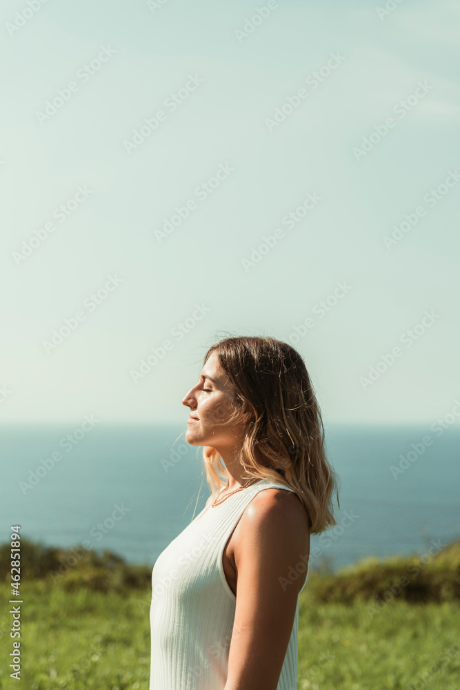 Beautiful young woman standing in park during summer on sunny day Beautiful young woman standing in park during summer on sunny day