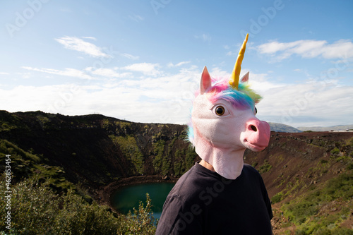 Man wearing unicorn mask standing at Kerid Crater, Selfoss, Iceland photo
