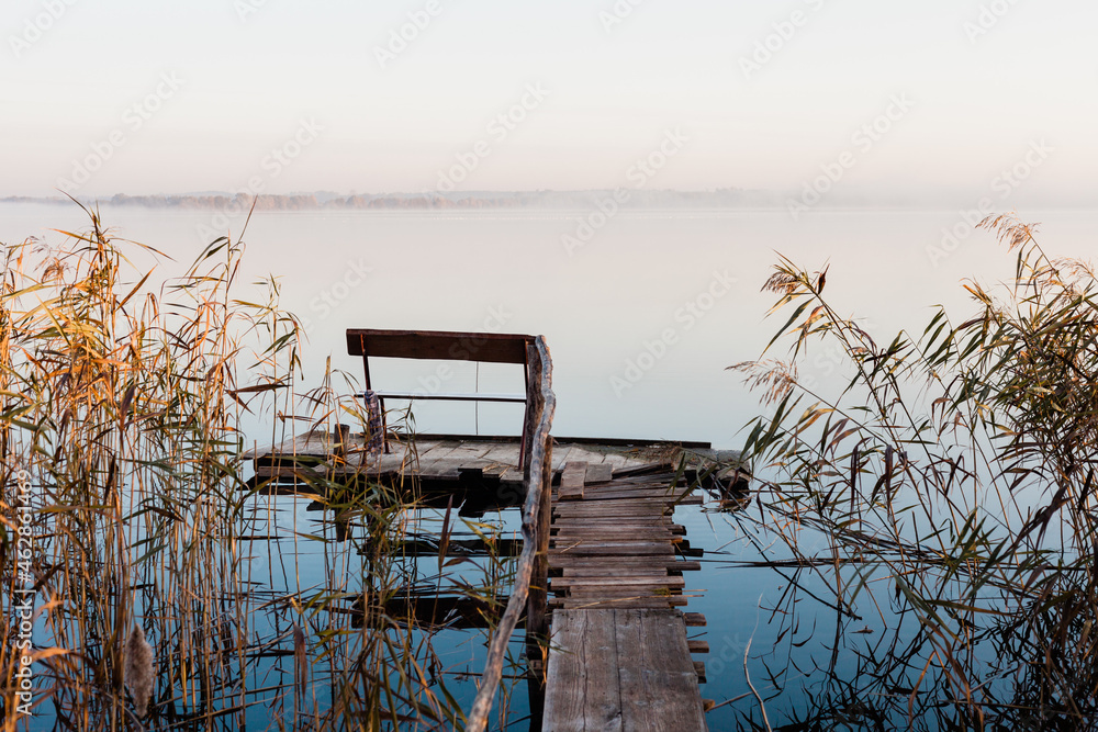Drewniany pomost nad jeziorem, mglisty poranek nad jeziorem z pomostem, ławeczka nad jeziorem, wschód słońca nad jeziorem z pomostem  - obrazy, fototapety, plakaty 