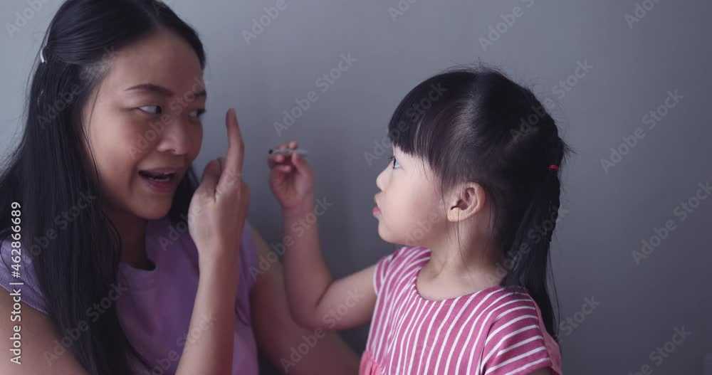 4K Video slow motion Asian little daughter doing make up her mom. Concept of love and connection of mother and kid. 4K Video slow motion Asian little daughter doing make up her mom. Concept of love and connection of mother and kid.