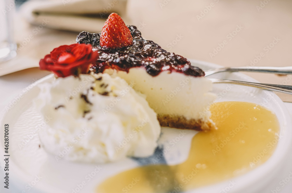 Una porcion de cheesecake con frutos rojos y nata Una porcion de cheesecake con frutos rojos y nata