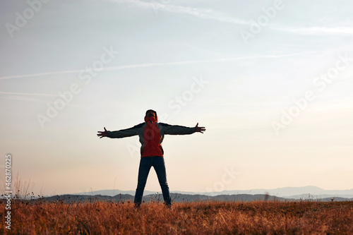 Man enjoying on a mountain hill top with panoramic landscape view.