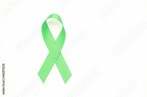 September world lymphoma awareness day and October world mental health day. Green ribbon isolated on a white background. Healthcare and medicine concept