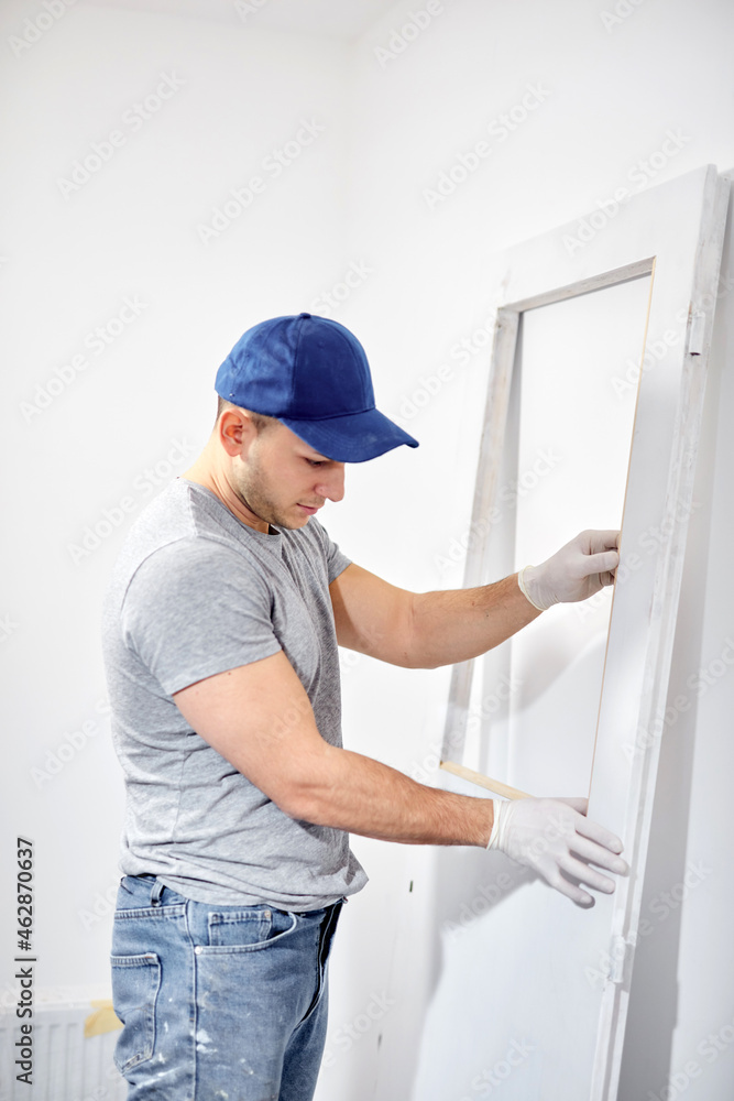 Young adult man painting and fixing on a DIY budget renovation of his new home apartment. Young adult man painting and fixing on a DIY budget renovation of his new home apartment.