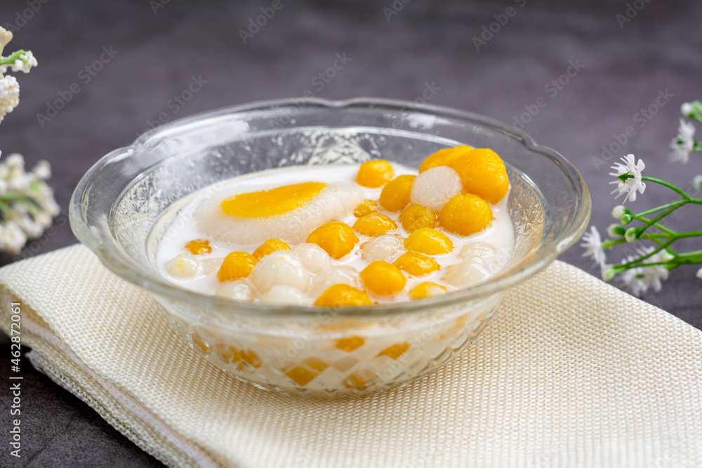 Pumpkin (white and yellow) rice dumpling in coconut milk (Bua Loy) in transparency bowl on wooden table. Delicious Thai dessert. Pumpkin (white and yellow) rice dumpling in coconut milk (Bua Loy) in transparency bowl on wooden table. Delicious Thai dessert.